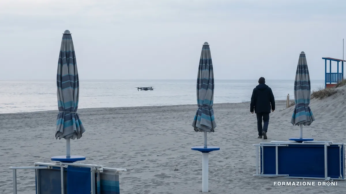 Spiaggia italiana quasi deserta di primavera con un piccolo drone in volo basso