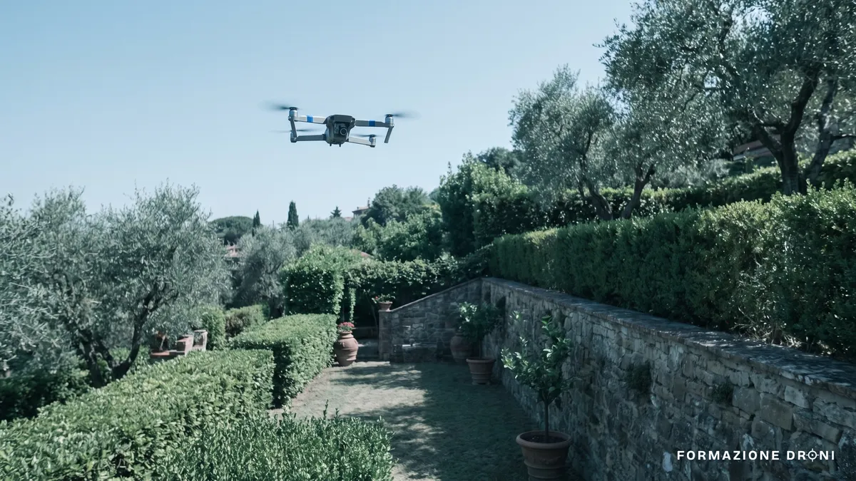 Drone in volo stazionario sopra un giardino residenziale visto dal basso contro il cielo estivo
