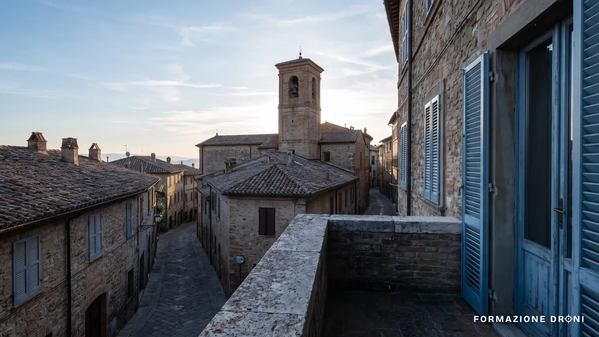 Tetti e campanile di un centro storico italiano all'alba, strade deserte