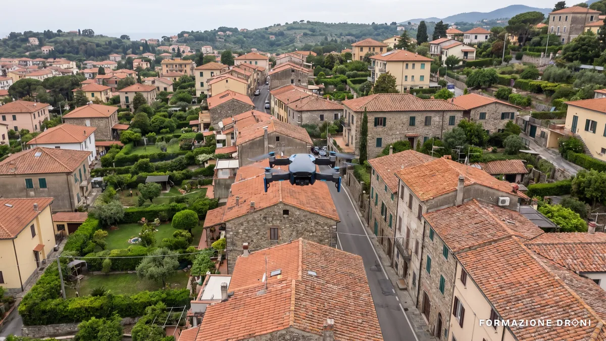 Drone con camera in volo sopra un quartiere residenziale italiano con giardini privati
