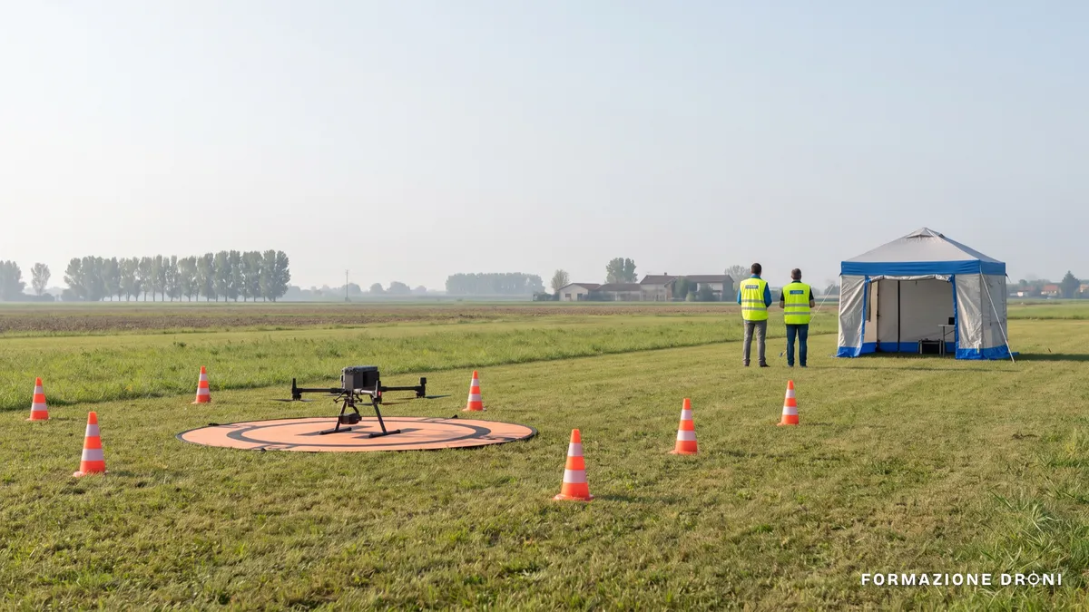 Area di addestramento all'aperto con drone su piazzola e coni di delimitazione