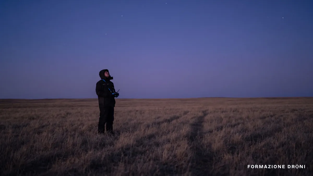 Pilota solo in un campo al tramonto con il radiocomando in mano